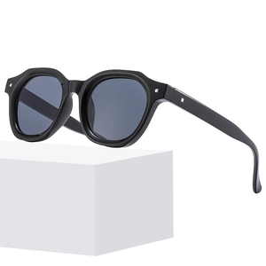 Modern square black frame sunglasses with dark grey lenses on a white geometric stand