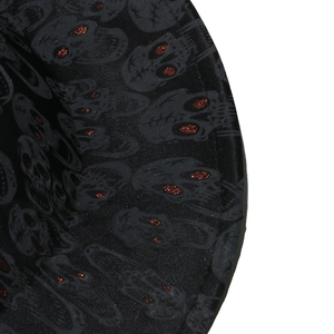 Detail of black fabric with grey skull patterns and red glitter eyes for Halloween hat