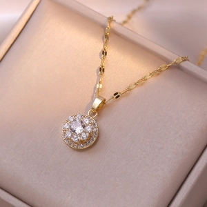 Elegante collar dorado con colgante de circón redondo brillante en joyero de color beige