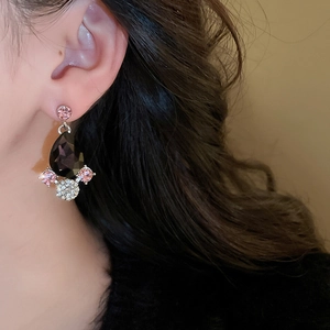 Detail of luxury teardrop jewelry set with black and pink stones on a female model