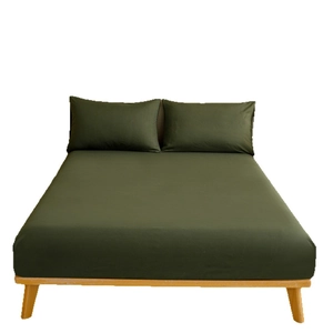 Solid dark green fitted sheet and pillowcase set on a light wood bed frame