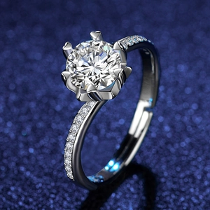 Elegant six-prong moissanite ring with heart shaped claws on a starry blue background