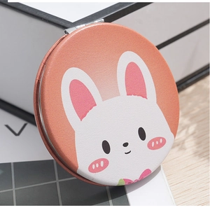 Close-up of a mini round folding mirror featuring a cute orange cartoon rabbit PU leather cover