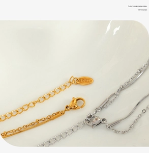 Detail of stainless steel double-layer chain with lobster clasp in gold and silver finish