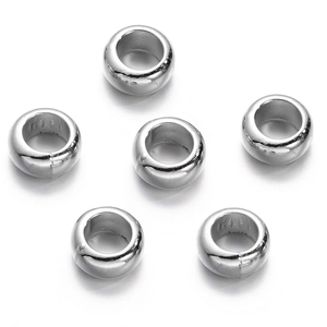 Detailed view of six bright silver CCB spacer beads with large holes on white background