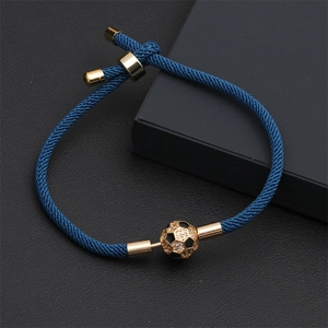 Dettaglio del bracciale intrecciato blu scuro con pallone da calcio dorato e zirconi