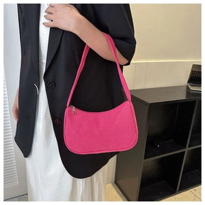 Pink corduroy baguette shoulder bag styled with a professional black blazer and dress