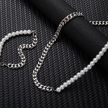Close-up of asymmetrical bracelet featuring half white pearls and half silver curb chain