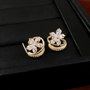 Detail of flower stud earrings with zircon petals and curved diamond-set band