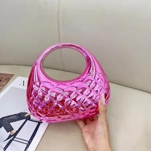 Detail of a shiny pink metallic quilted handbag in a semi-moon shape for evening wear