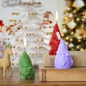 Tres velas de gnomos navideños de colores con texturas detalladas en un ambiente festivo