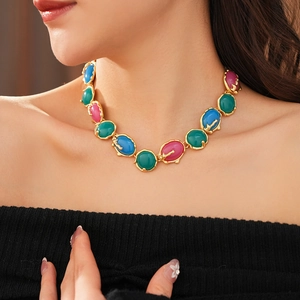 Gros plan d'un collier vintage doré avec des pierres ovales en résine colorée