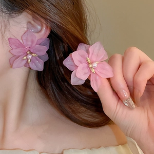 Close-up of pink petal flower earrings featuring faux pearl centers and gold accents
