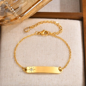 Gold stainless steel bar bracelet with sunburst engraving and sparkling zircon stone