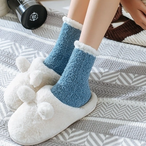 Blue coral fleece socks paired with plush white slippers for winter home comfort