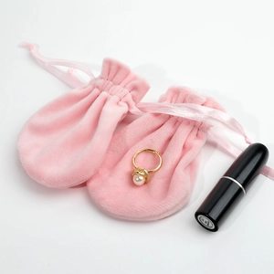 Pair of pink velvet drawstring pouches for jewelry storage on white background