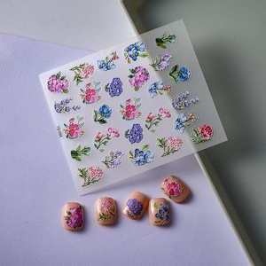 5D floral embossed nail stickers with colorful flower designs on soft textured background