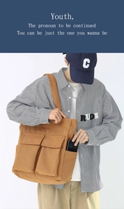 Detail of vintage brown canvas tote bag featuring functional double front pockets and sturdy fabric