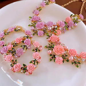 Floral necklace and bracelet set with pink resin roses and pearls on a gold chain