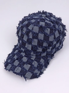 Detailed close-up of blue denim plaid baseball cap featuring distressed frayed edges