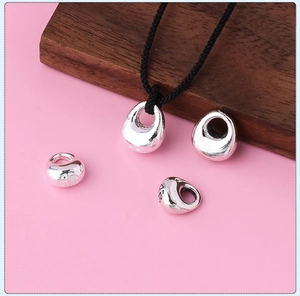 Macro detail of polished s925 sterling silver charms with engraved Fu character and black cord
