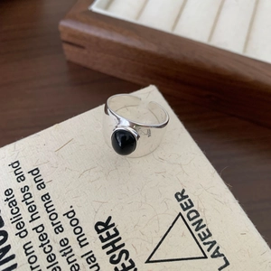 Detail of vintage 925 silver ring featuring oval black agate stone and wide band