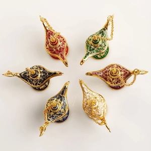 Set of six vintage Aladdin magic lamps in assorted colors with ornate gold metal engravings