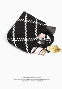Top-down view of woven checkered tote bag with daily essentials inside showing large capacity