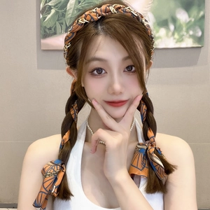 Elegant silk hair ribbon with orange and blue retro chain patterns on a braided hairstyle