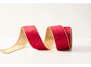 Macro detail of red velvet ribbon with golden edges and Merry Christmas foil printing