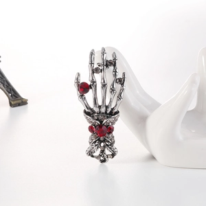 Punk skeleton hand brooch with red rhinestones on a silver metal base jewelry