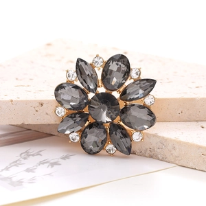 Detail view of flower-shaped zinc alloy crystal charm on a textured stone surface