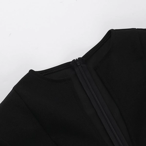 Detailed close-up of V-neckline with invisible zipper on black bodycon dress