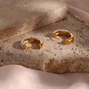 Macro view of 18K gold plated stainless steel hoop earrings with white pearl accents