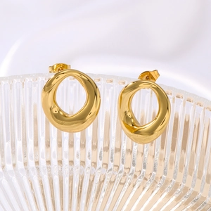 Boucles d'oreilles rondes dorées polies au style minimaliste sur bord de verre