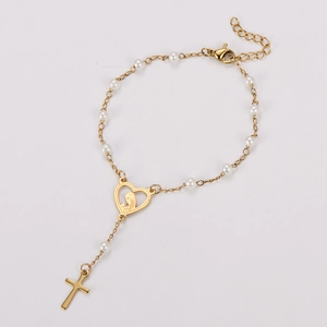 Vue détaillée d'un bracelet en perles dorées avec médaillon cœur et pendentif en croix