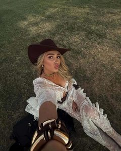 Dettaglio di top in pizzo bianco con collane dorate e cappello a tesa larga set