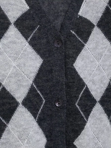 Detailed close-up of grey and white argyle knit texture with V-neckline and dark buttons