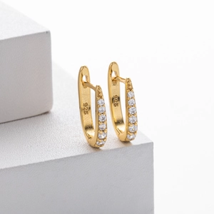 Detailed close-up of 925 sterling silver stamp on gold plated hoop earrings with zircons