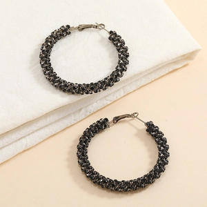 Detailed view of large black hoop earrings featuring shimmering encrusted rhinestones