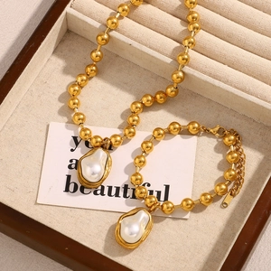 Detailed shot of 18K gold plated bead bracelet and necklace with baroque pearls in a gift box