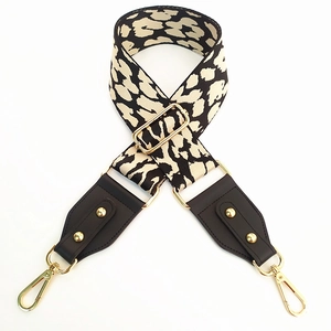 Detail of adjustable black and white leopard print strap with leather and gold hardware