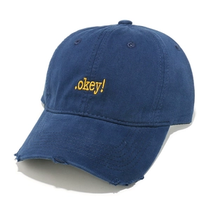Close-up of distressed brim details and yellow .okey! embroidery on navy baseball cap
