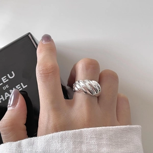Macro shot of a twisted 925 silver croissant ring featuring a polished metallic texture