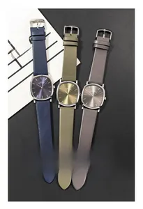 Flat lay of ultra-thin oval watches with colorful leather straps on a modern background