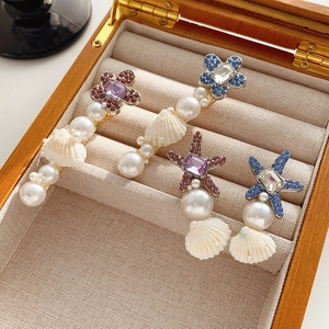 Vue macro détaillée de barrettes à thème marin avec strass, perles et coquillages