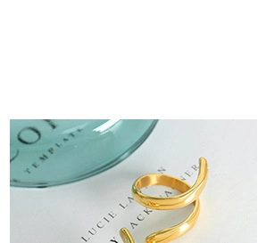 Dettaglio macro di anello a spirale placcato oro 18K con curve in metallo liscio