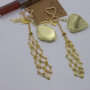 Detailed view of golden mesh pendant keychain with heart charms and bow accent