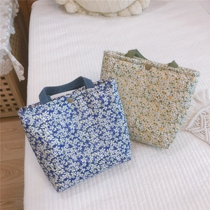Floral print canvas lunch bags in blue and beige with metal snap button and dual handles