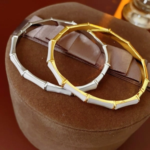 Detailed close-up of bamboo-shaped gold and silver bangles on luxury velvet